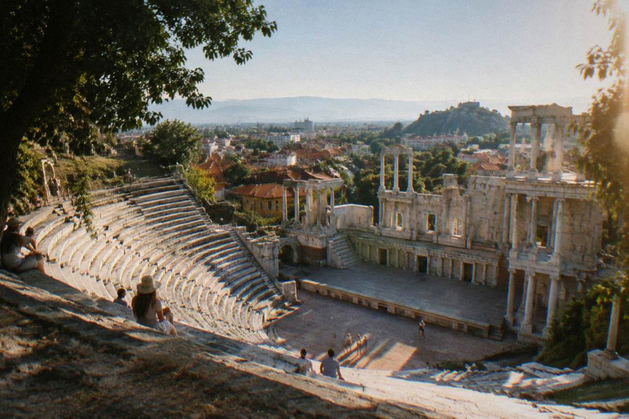 The Ancient Theatre of Philippopolis under a clear summer sky with the city rooftops below