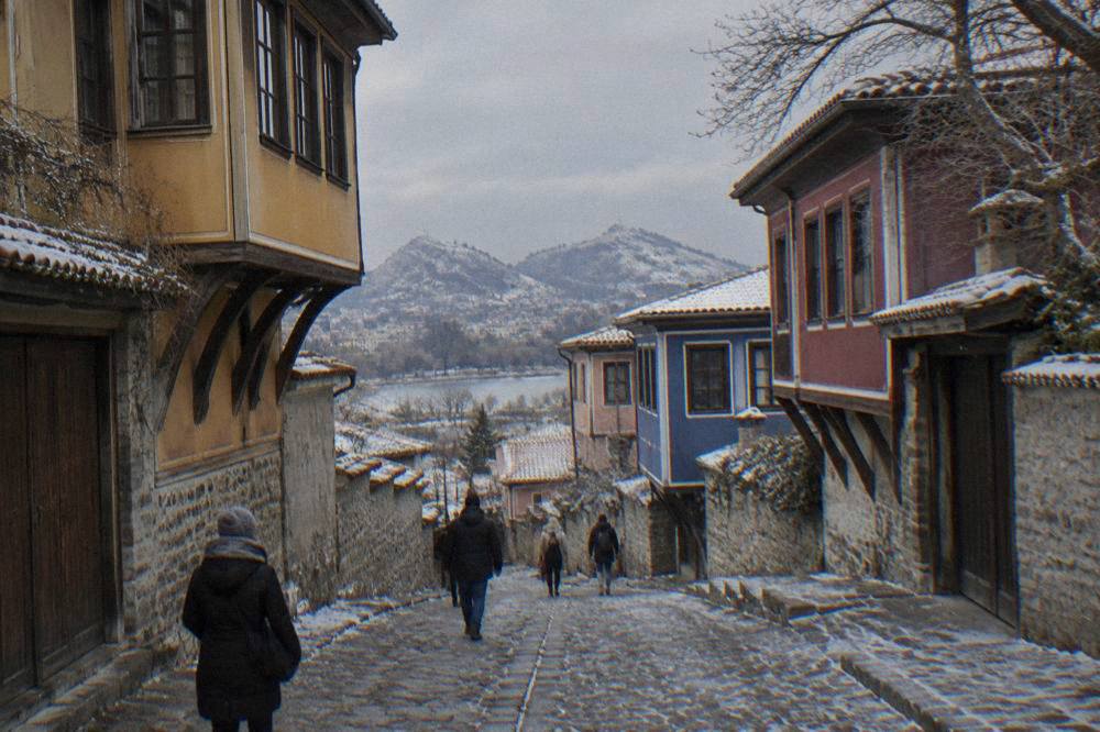 Frost-covered cobblestone lane in Plovdiv Old Town with pastel revival houses on either side