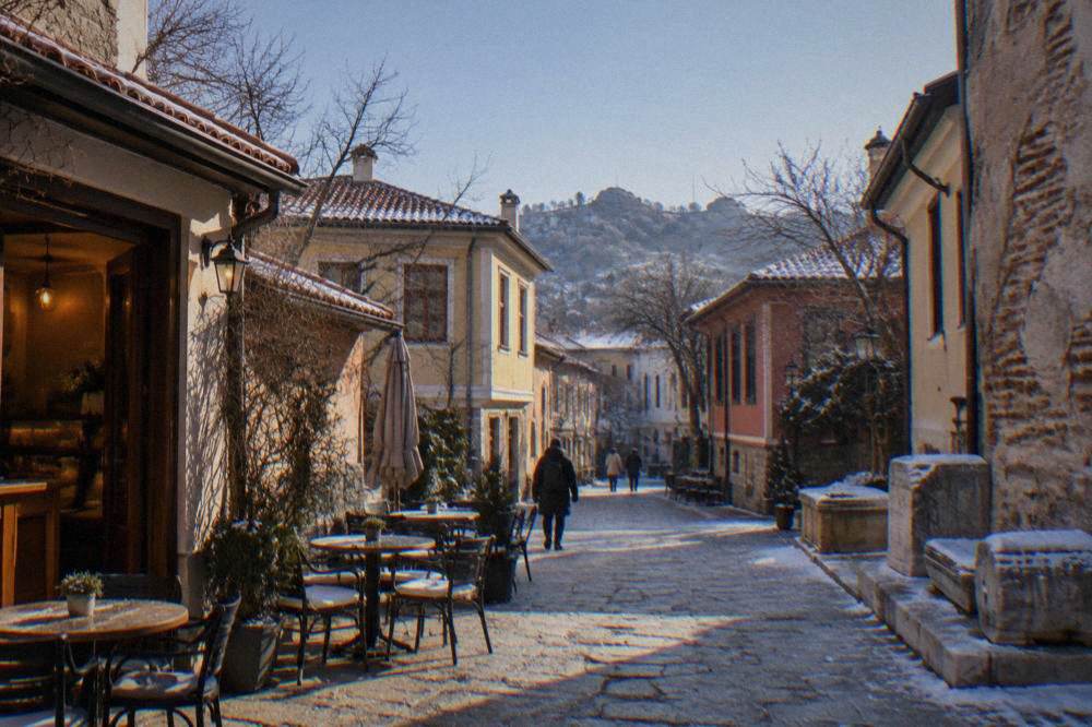 A narrow Kapana street in winter with warm light spilling from a small cafe doorway