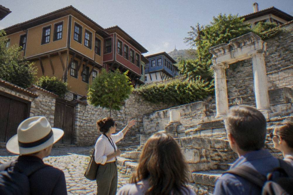 A tour guide speaking to a small group beside Roman ruins in Plovdiv