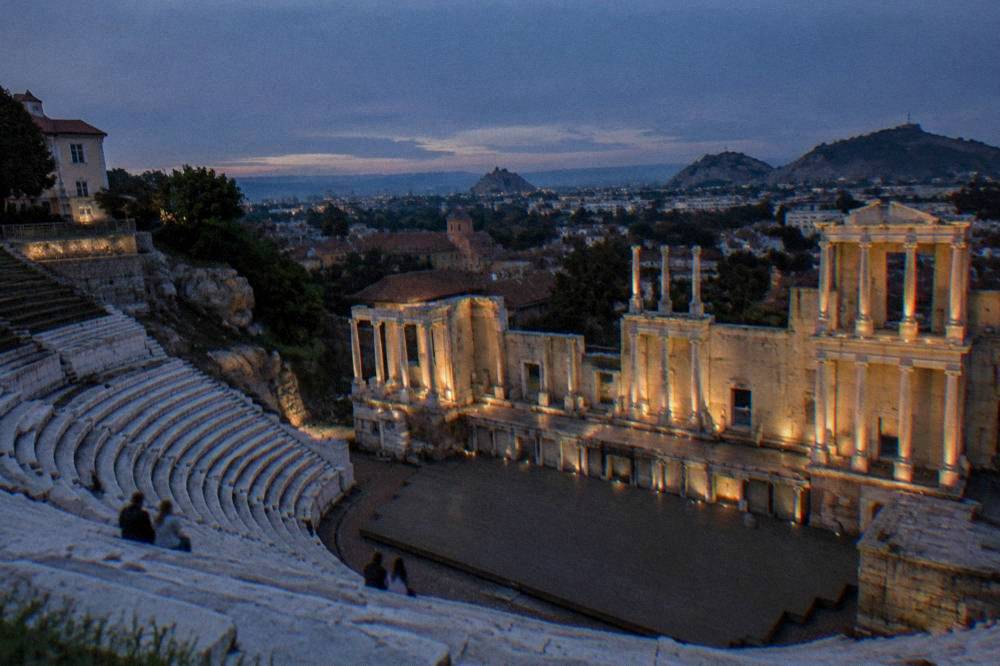 The marble rows of the Ancient Theatre of Philippopolis illuminated against a dark sky