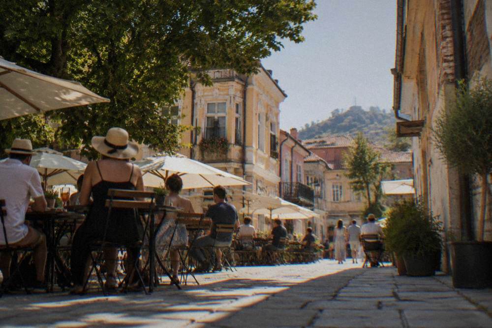 Crowded outdoor cafe tables on a warm summer evening in the Kapana district of Plovdiv