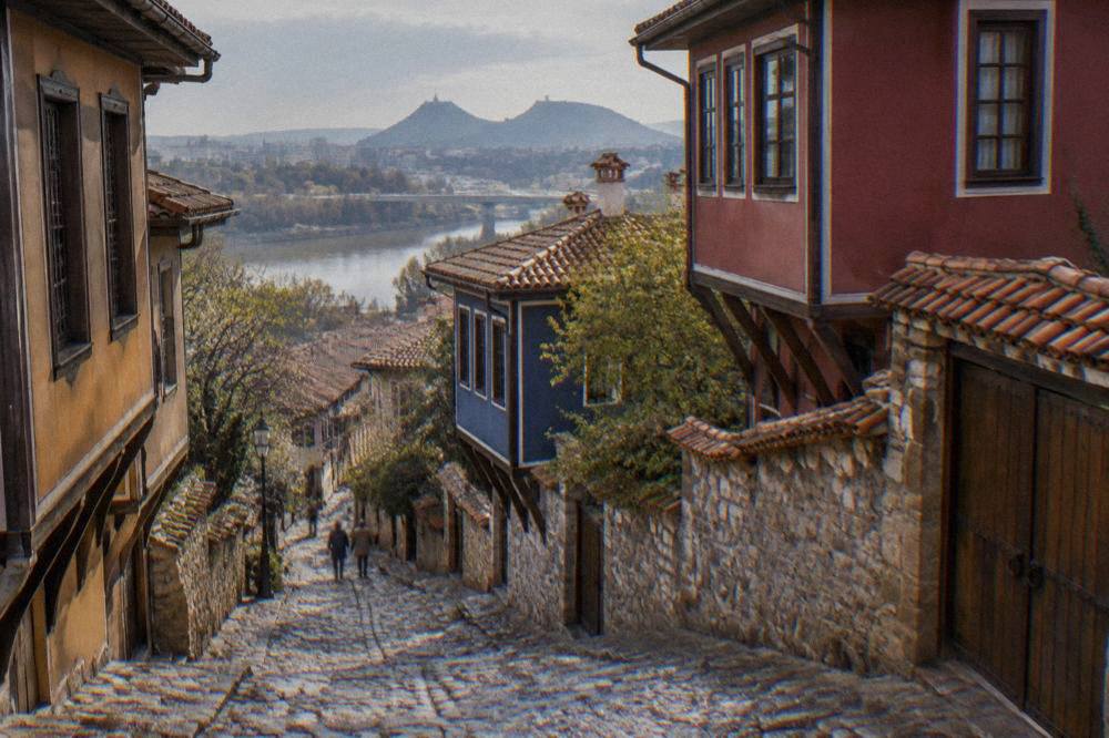 Stone-paved lane climbing between restored houses in Plovdiv Old Town