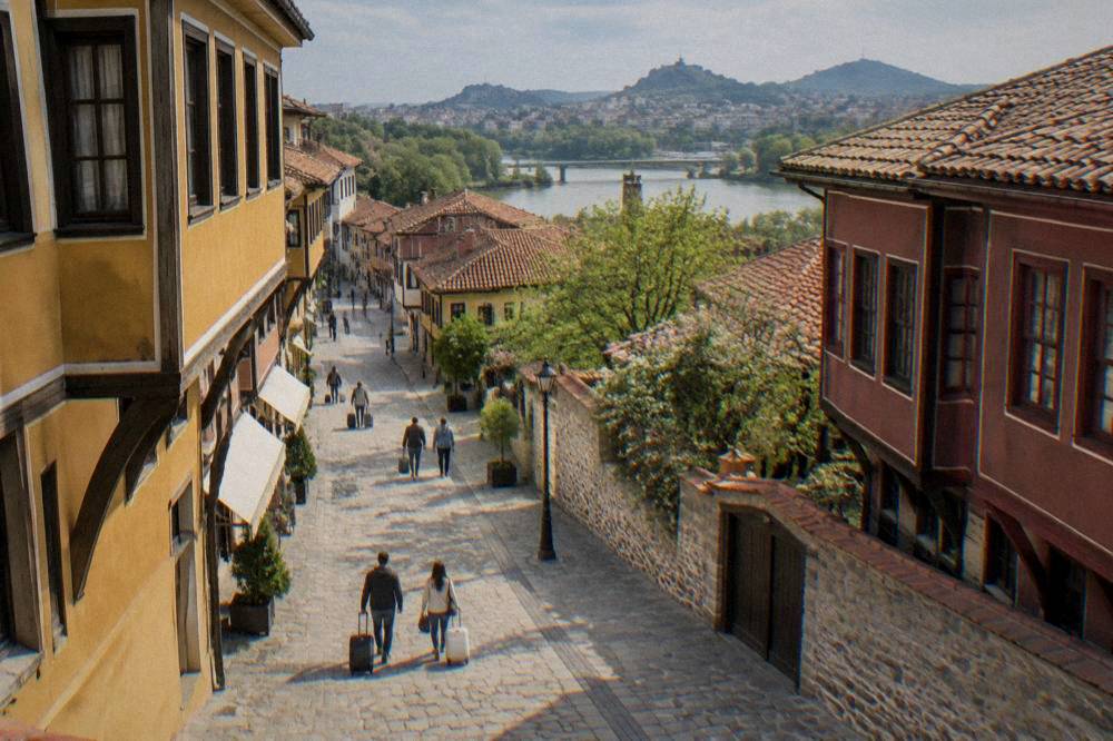 Travellers with suitcases walking along a wide pedestrian shopping street in central Plovdiv