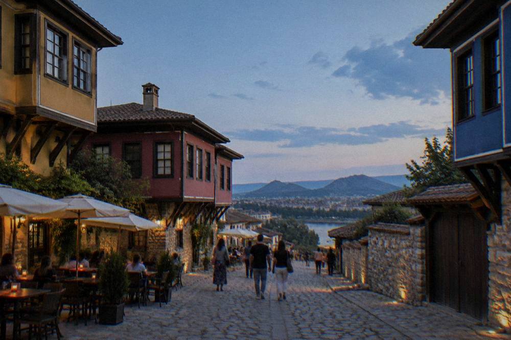 People strolling on a wide pedestrian street with cafe tables in Plovdiv city centre