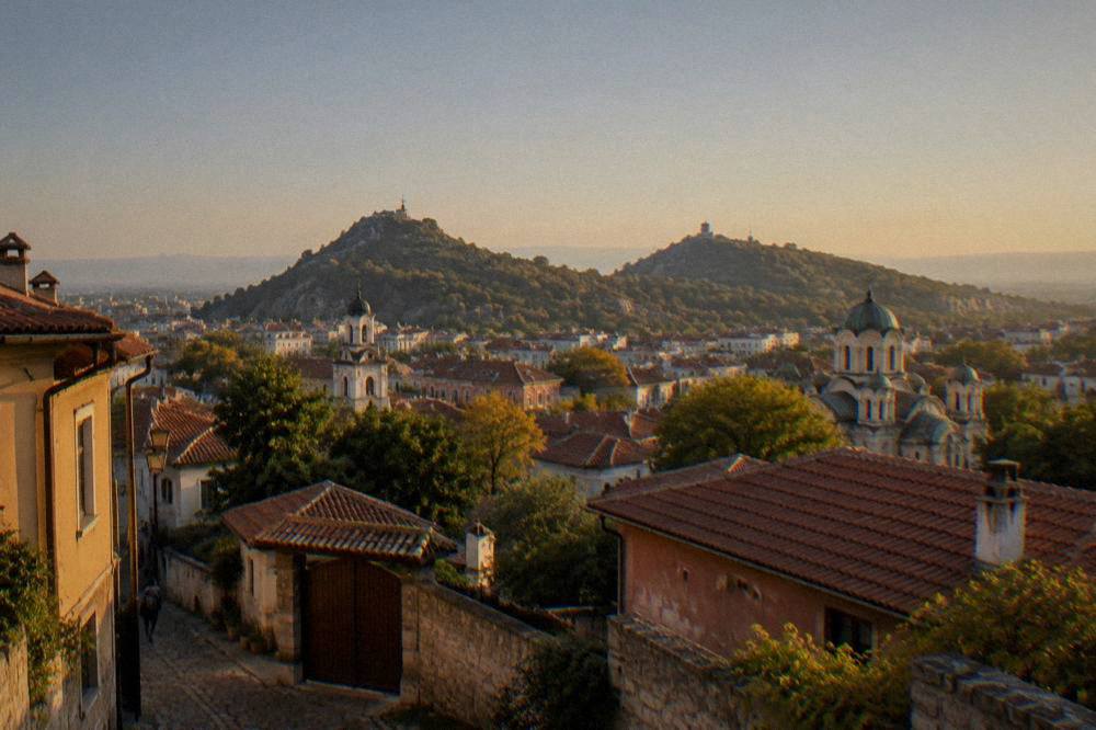 A city panorama showing green hills rising above rooftops and church domes