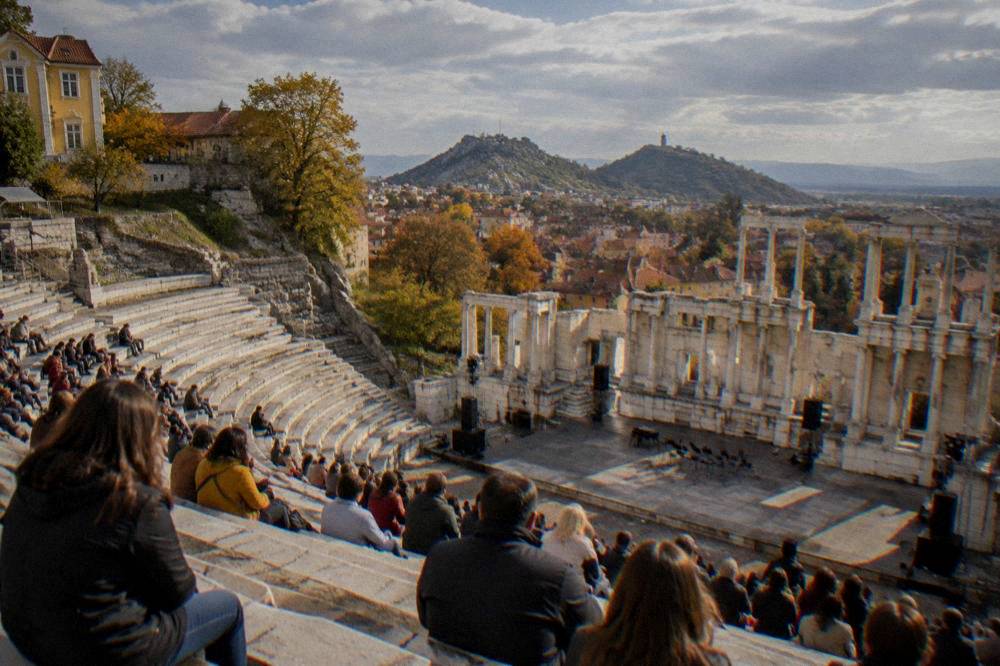 A crowd gathered in a city square for an open-air cultural festival in autumn