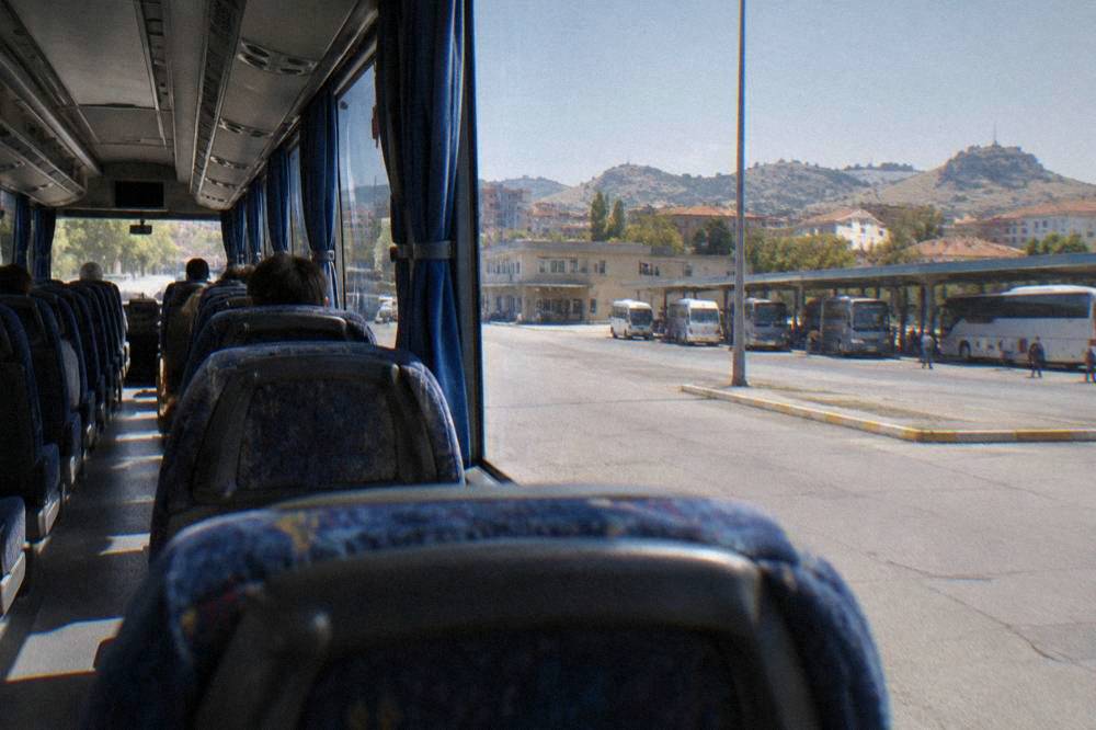Interior of a regional bus with rows of seats and a clean aisle