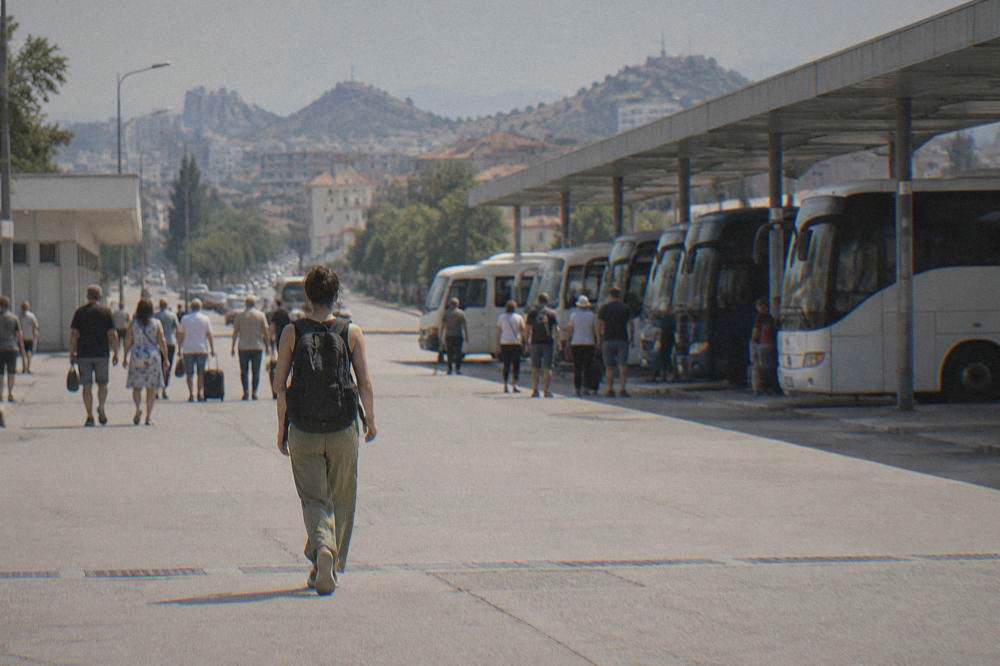 Traveller with a backpack walking through a busy station concourse toward departures