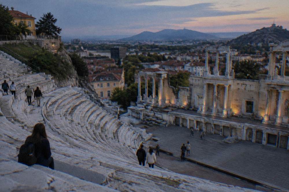Visitors walking among marble rows of the Ancient Theatre of Philippopolis