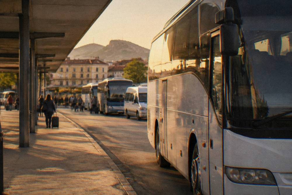 An intercity coach parked at a bus station platform in a Bulgarian city