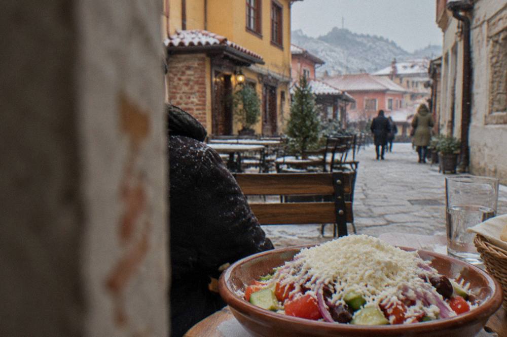 A close view of a shopska salad topped with grated white cheese