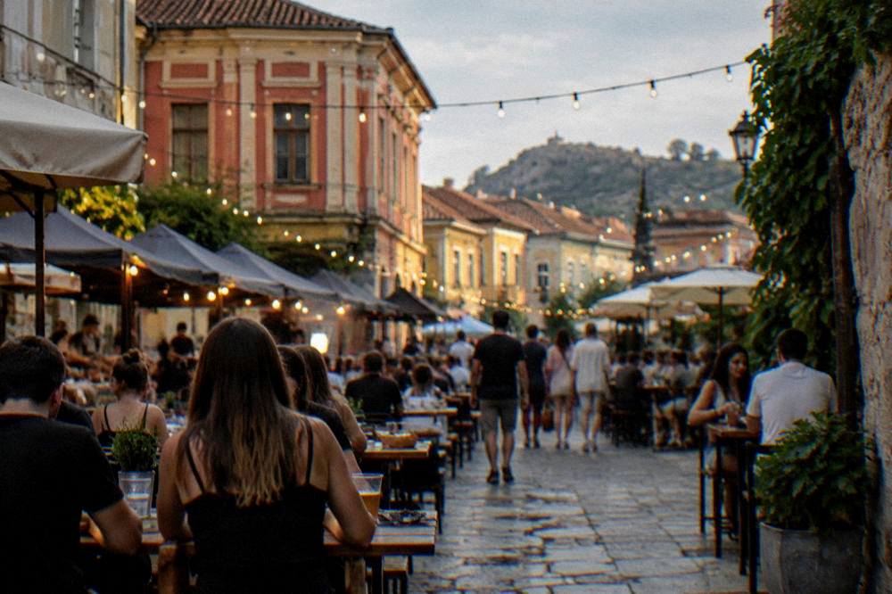 Crowded outdoor tables at a street food festival with lights strung overhead