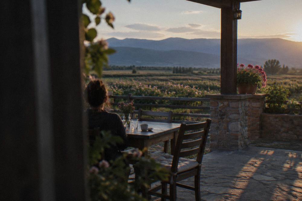 Rural Bulgarian guesthouse terrace overlooking vineyards at dusk