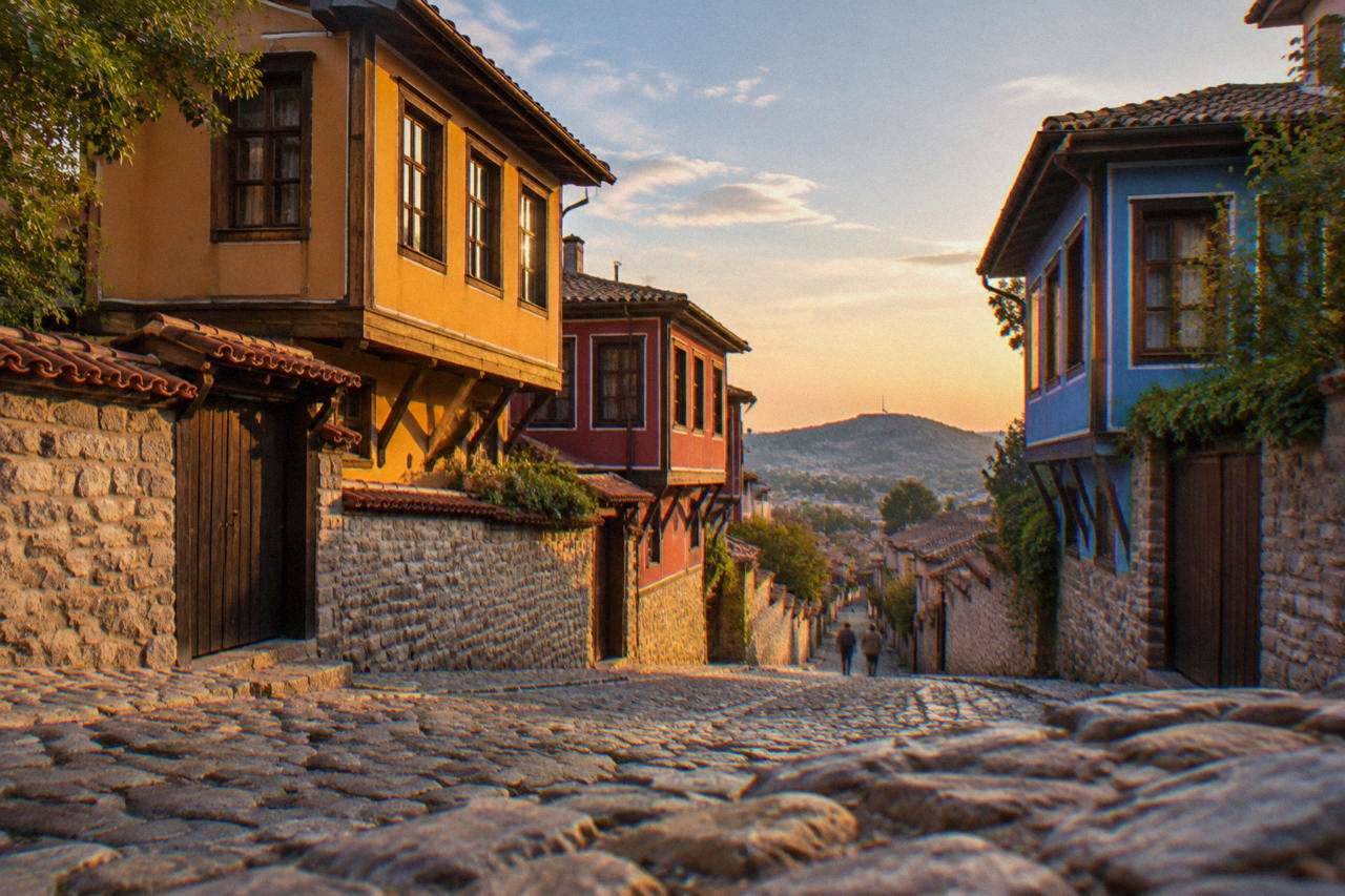 Colourful revival-era houses on a cobbled street in Plovdiv Old Town under an evening sky