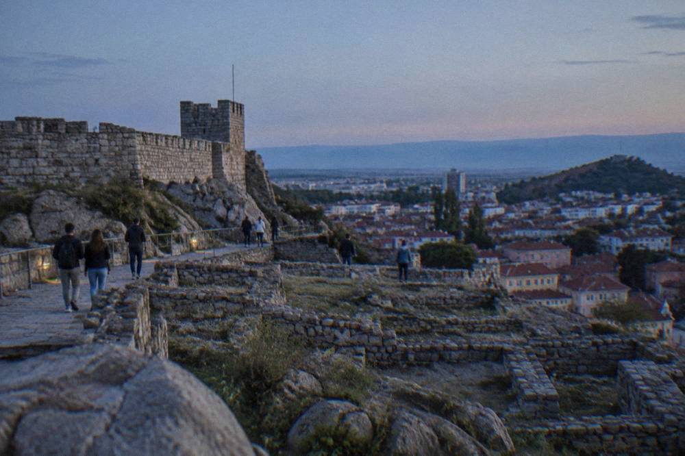 Visitors walking among the excavated foundations on Nebet Tepe hill above Plovdiv