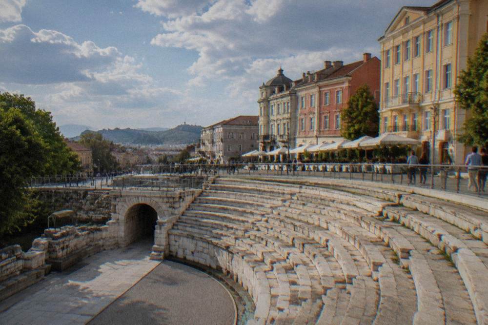 The curved stone sphendone of the Roman Stadium beside the pedestrian Main Street in Plovdiv