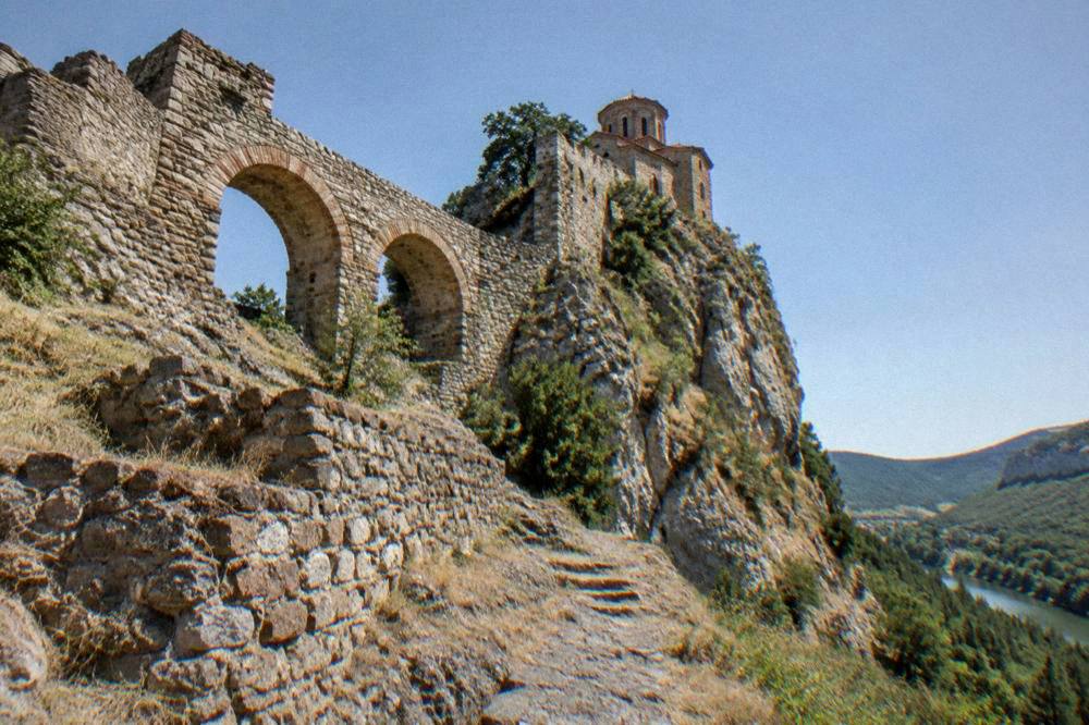 Stone arches of Asen's Fortress on a rocky ridge above the valley