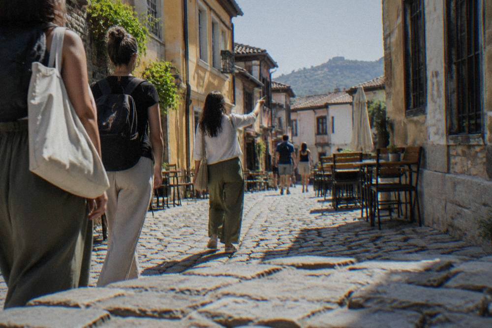 A guide leading a small group down a narrow cobbled Kapana street