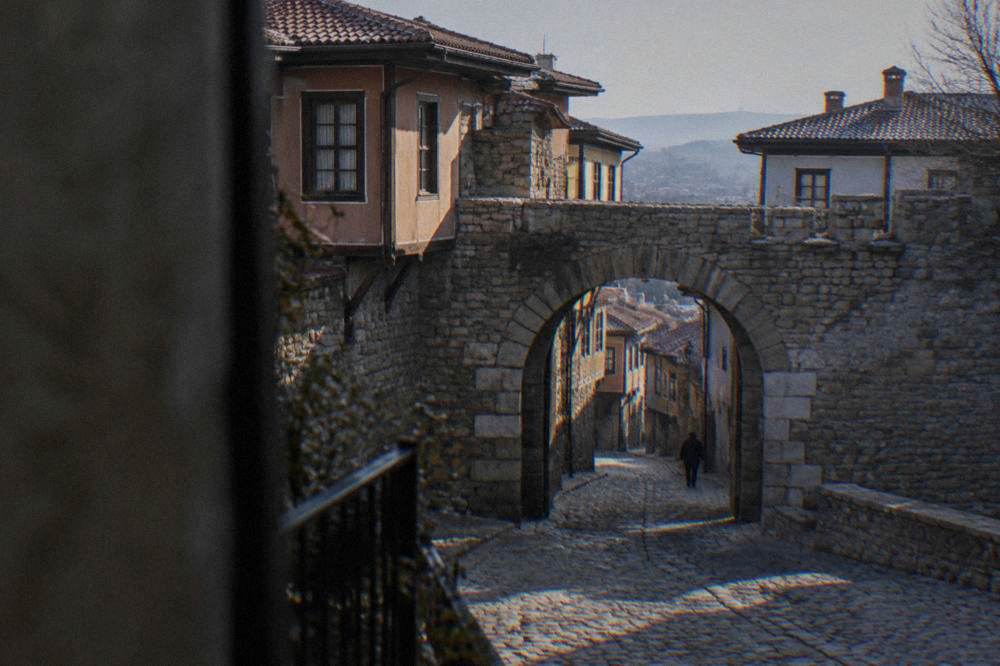 Stone gate of Hisar Kapia with old houses rising above it in Plovdiv