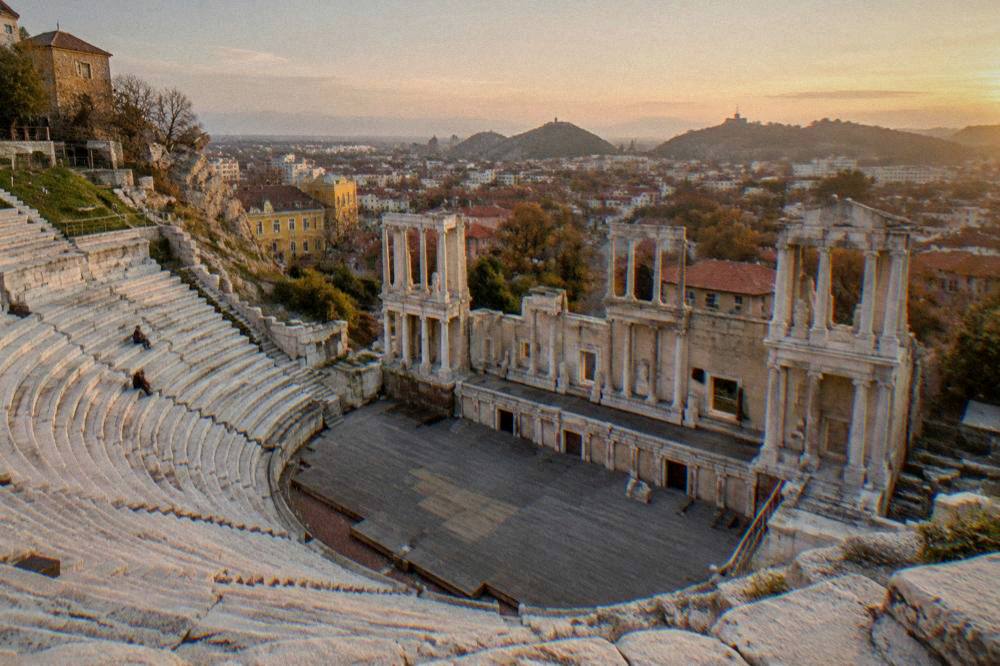 Ancient Theatre of Philippopolis at golden hour with the city spread below
